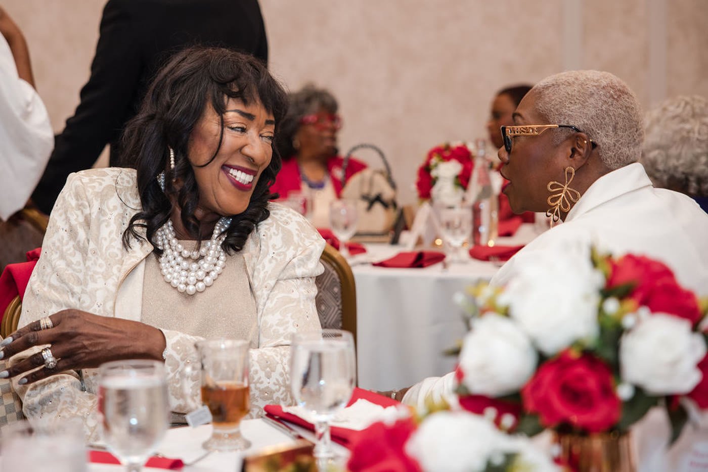 Two guests laughing together at a banquet table