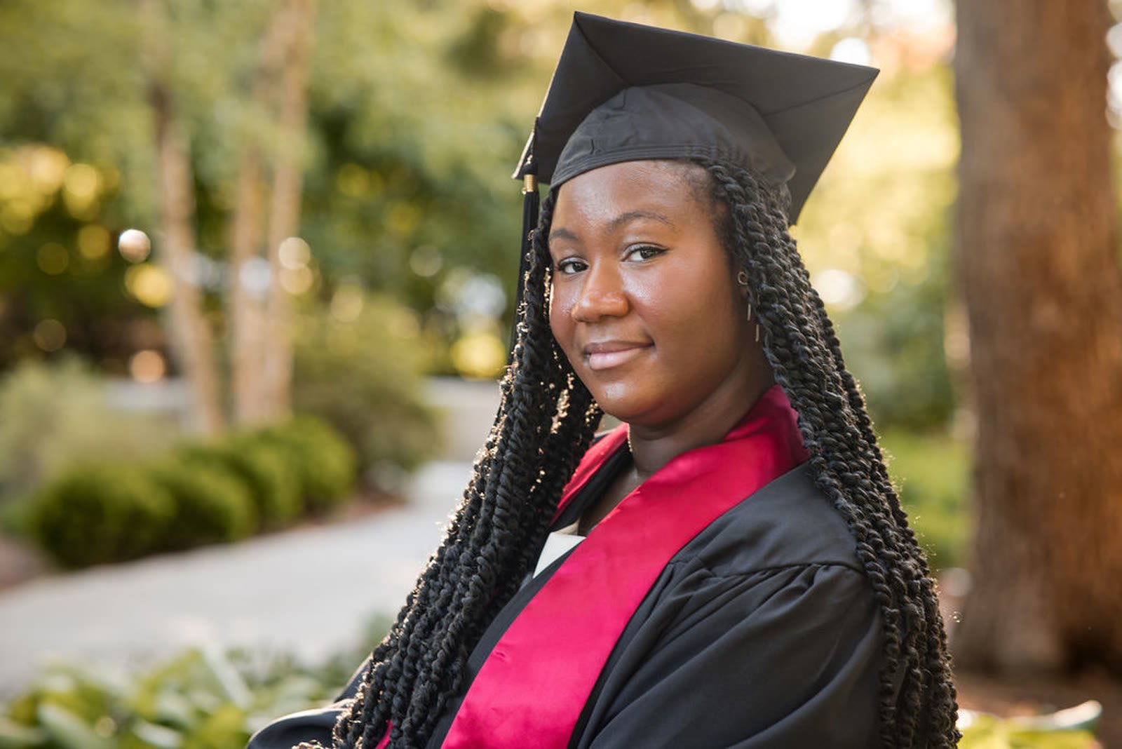 Graduate in cap looking to camera in warm evening light