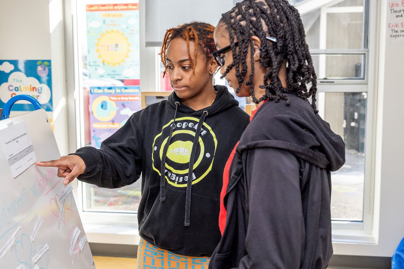 Two students working at a classroom whiteboard